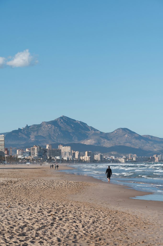 vista panorámica de playa hombre caminando sobre la arena